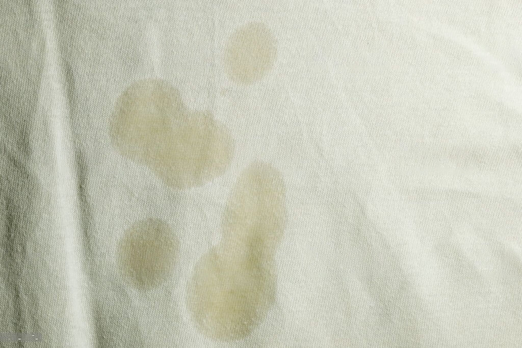 A white sheet with visible stains and discoloration.